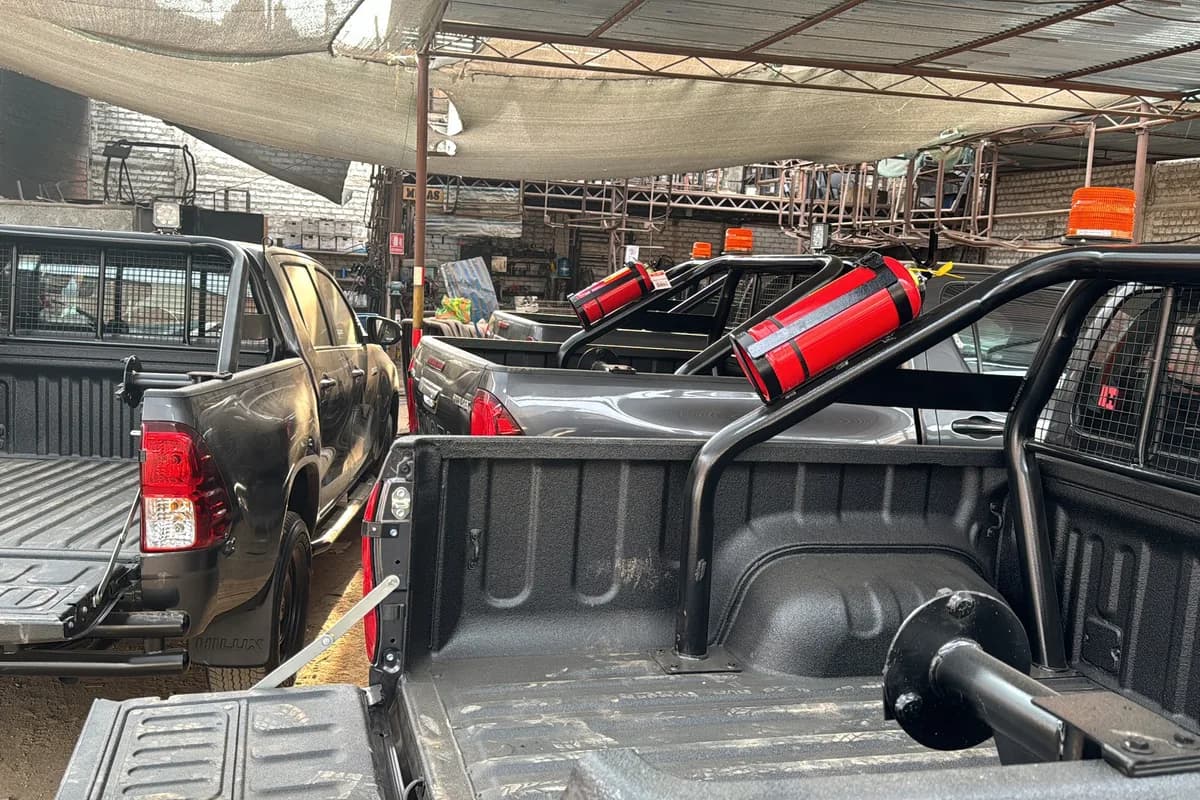 Camionetas en el taller siendo equipadas en simultáneo con estructuras antivuelco y extintores