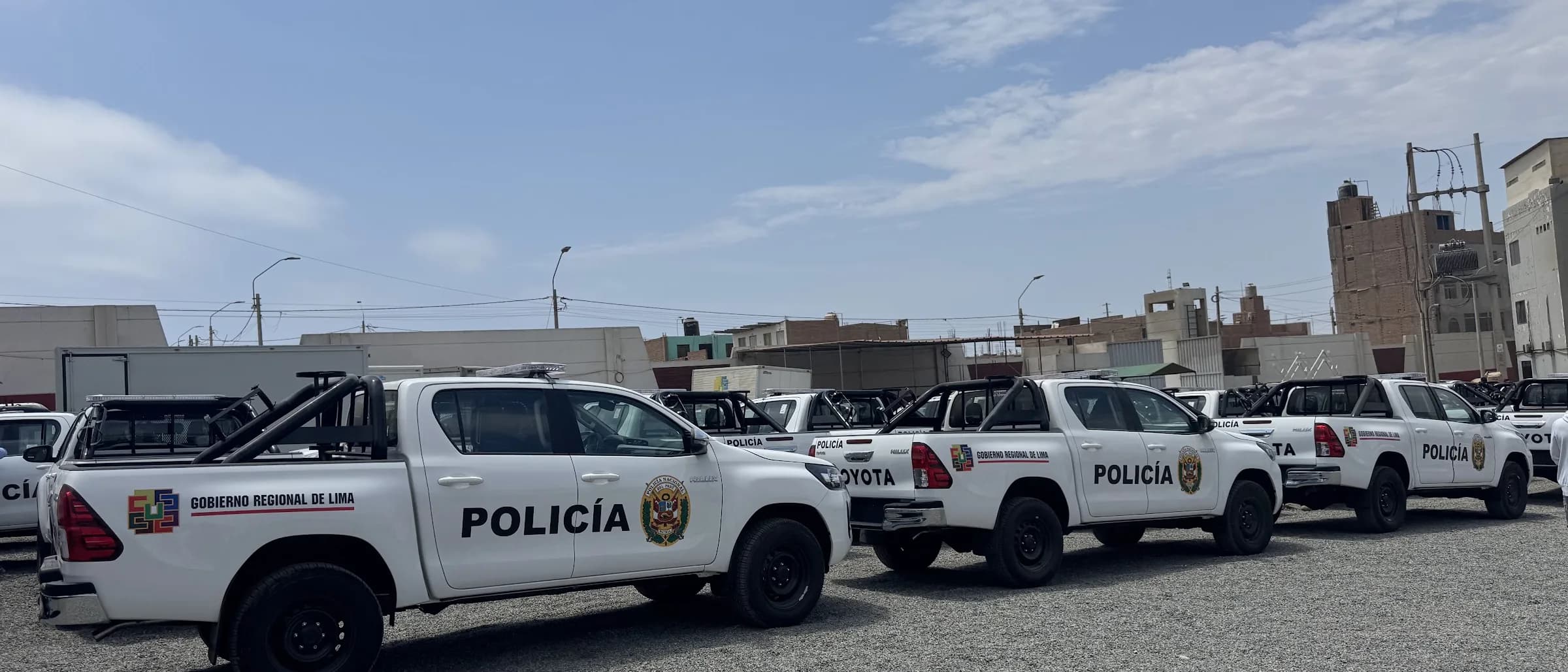 Filas de camionetas policiales equipadas con estructura antivuelco y barra de luces en el patio de entrega