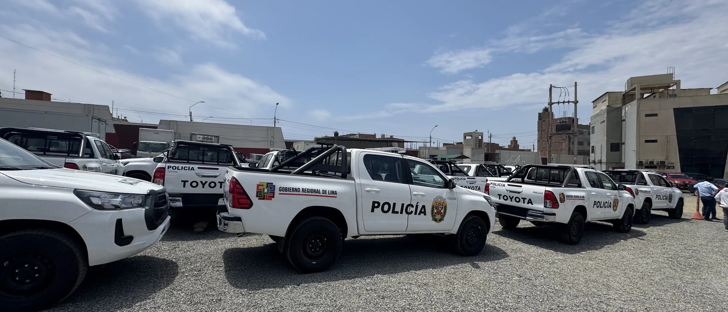Camionetas policiales con estructura antivuelco alineadas en el patio bajo cielo despejado