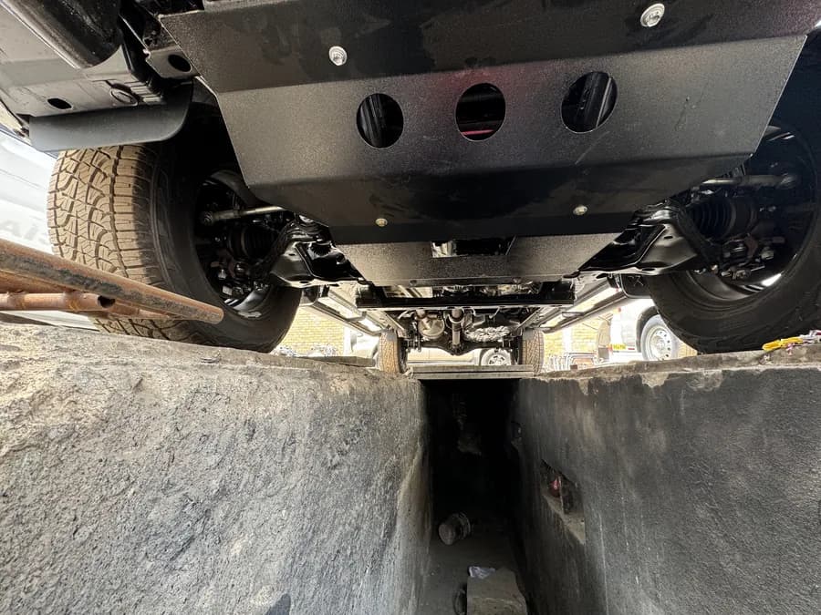 Protector metálico de cárter instalado bajo el motor de una camioneta